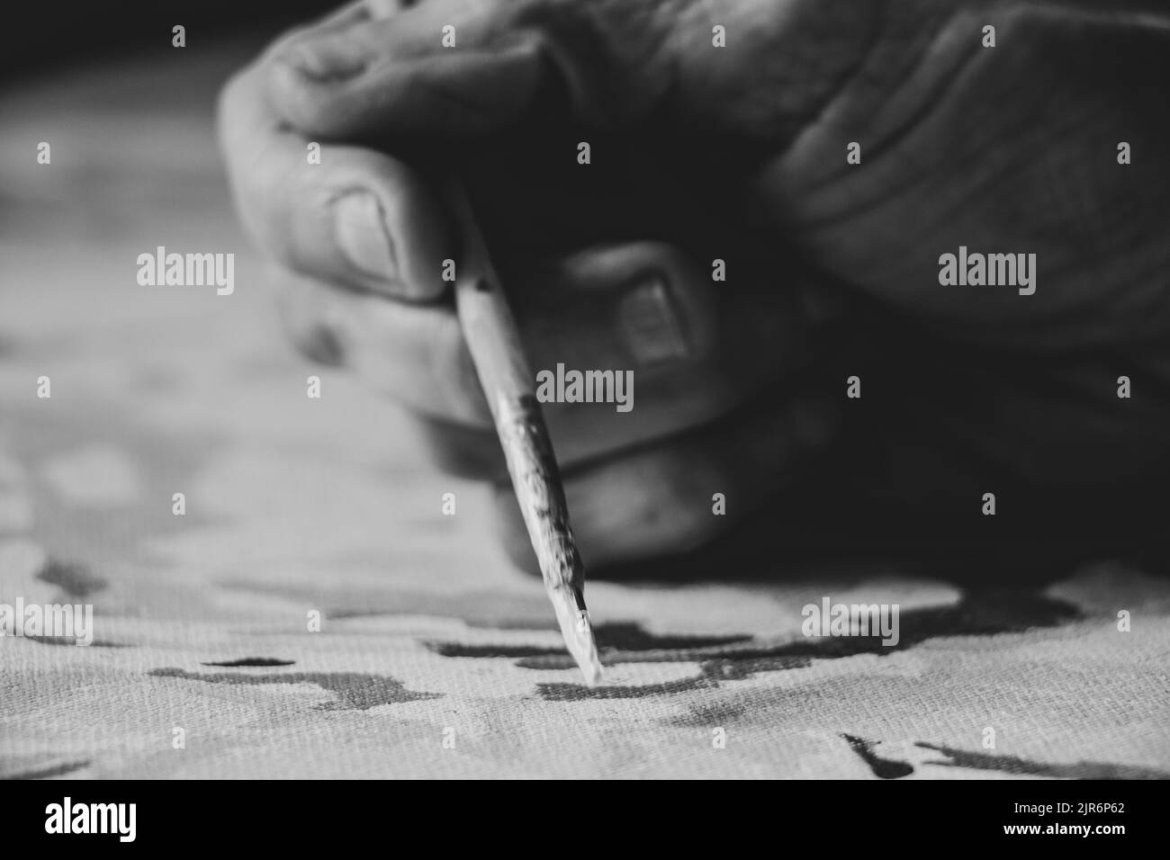 Die Hand einer alten Frau hält einen Pinsel in karski im Bild, der Künstler zeichnet sein Bild, ein Kunstwerk, ein Bild Stockfoto