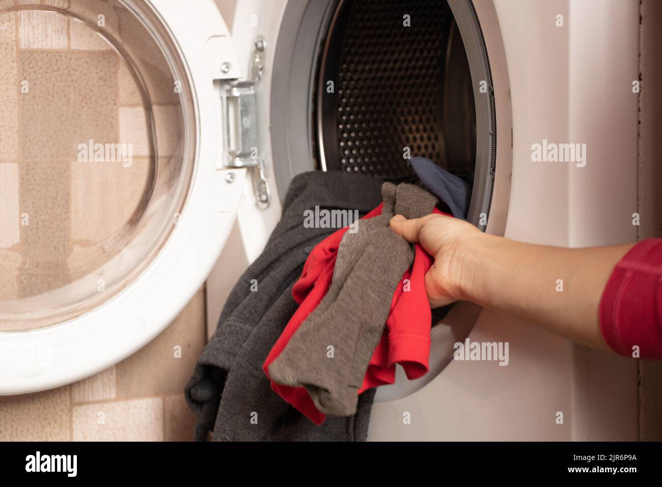 Dinge in der Waschmaschine, Waschmaschine mit Dingen zu Hause in der Küche, Waschen, Hausarbeit Stockfoto