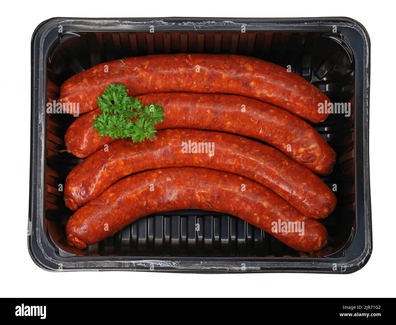Draufsicht auf rohe würzige Merguez-Würste, garniert mit Petersilie in schwarzer Kunststoffverpackung Stockfoto