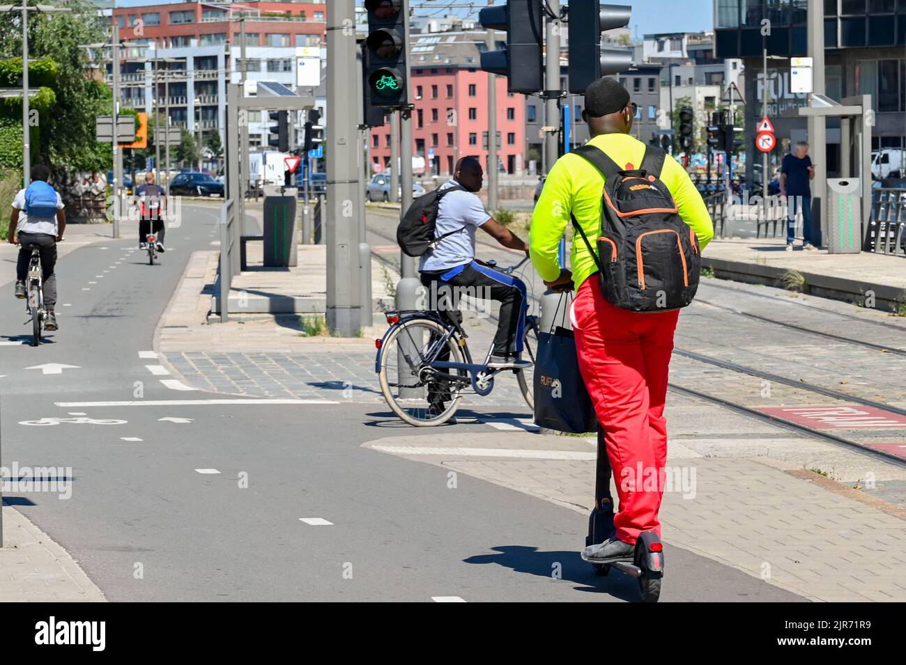 Antwerpen, Belgien - 2022. August: Person, die auf einem Elektroroller auf einer Fahrradspur entlang einer Straße im Stadtzentrum fährt Stockfoto