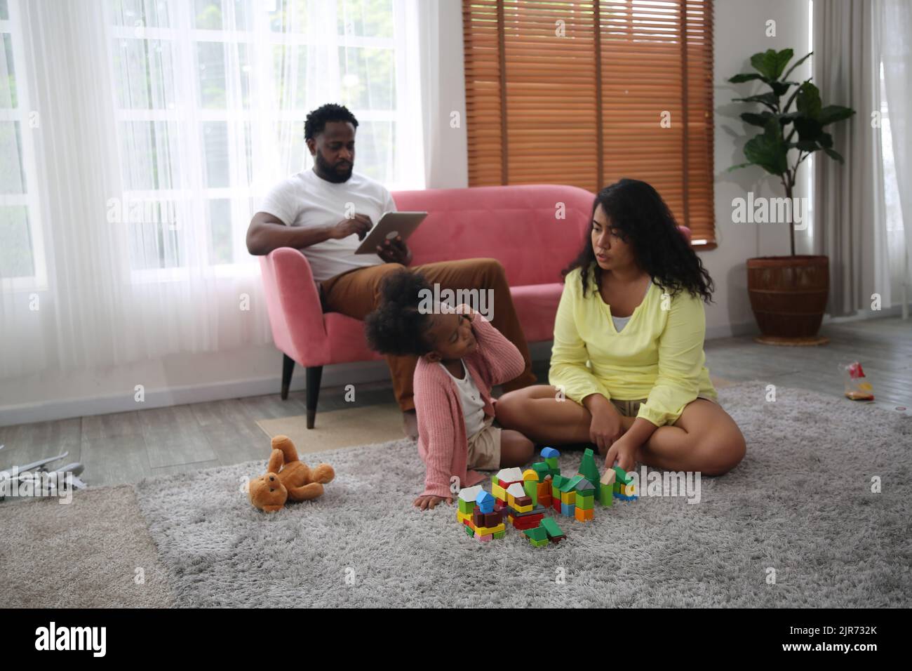 Aufnahme einer glücklichen interracial Familie von Mutter Vater und ihrer Tochter in einer modernen Wohnung. Stockfoto