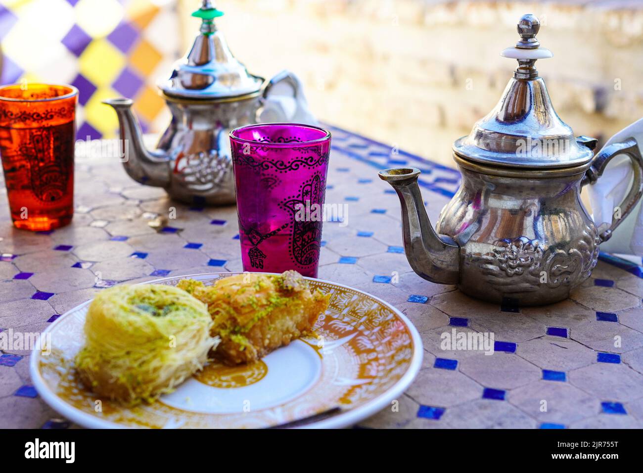 Minztee im marokkanischen Stil und Nahost-Süßigkeiten auf der Terrasse der El Bañuelo Teteria in Granada, Spanien Stockfoto