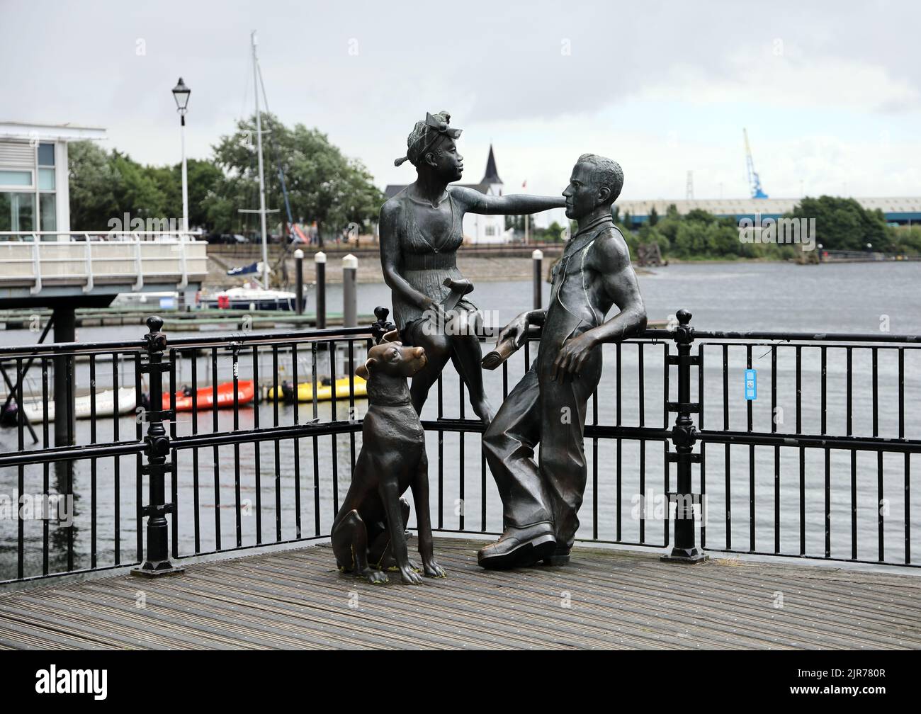 Leute wie wir - Statue Gruppe in Cardiff Bay. Sommer 2022. Cardiff Bay. August 2022. Norwegische Kirche im Hintergrund. Stockfoto