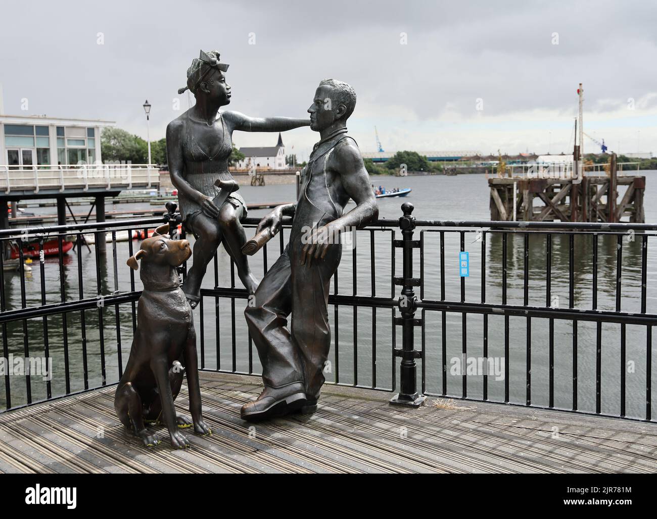 Leute wie wir - Statue Gruppe in Cardiff Bay. Sommer 2022. Cardiff Bay. August 2022. Norwegische Kirche im Hintergrund. Stockfoto