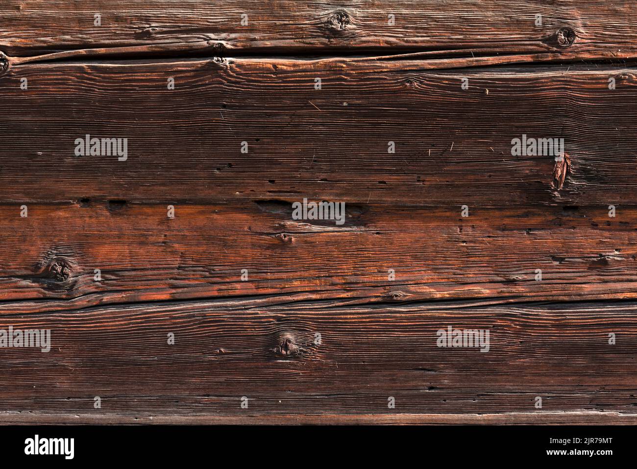 Makroaufnahme einer alten verwitterten dunkelbraunen gesprungenen Holzoberfläche mit schöner grober Maserung. Stockfoto