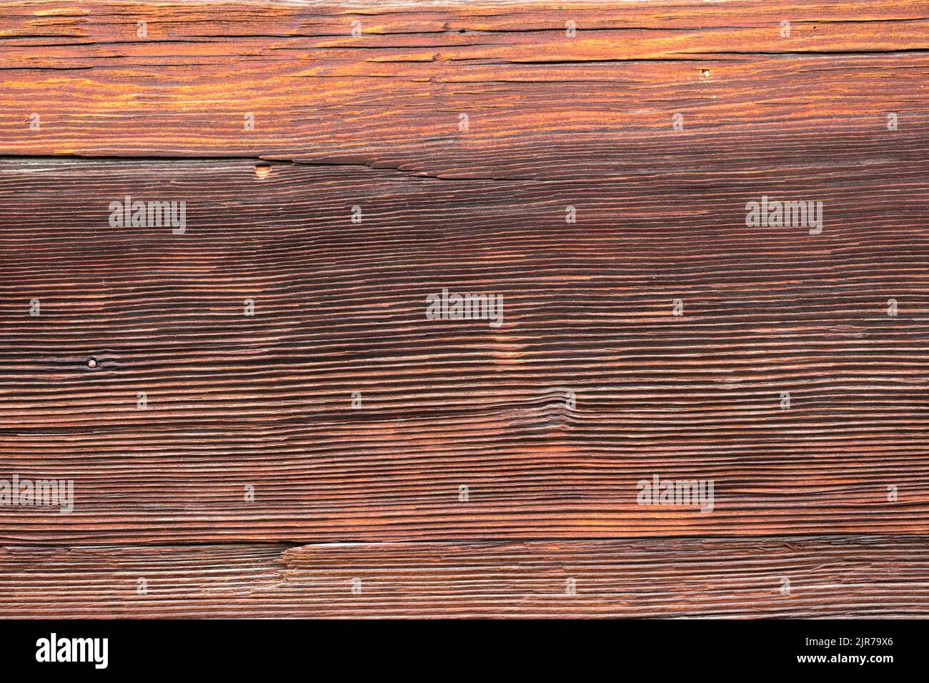 Makroaufnahme einer alten verwitterten dunkelbraunen gesprungenen Holzoberfläche mit schöner grober Maserung. Stockfoto