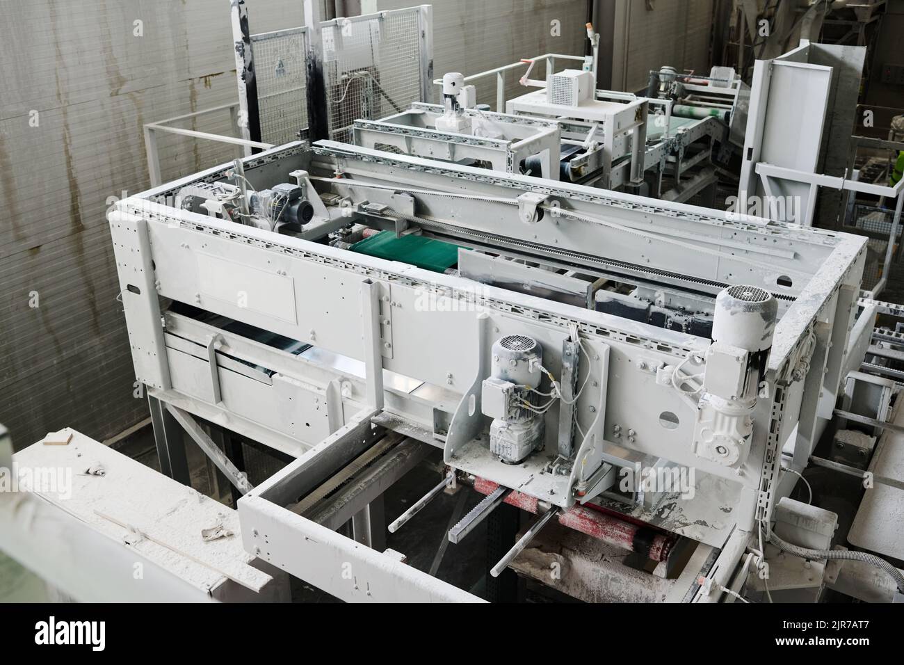 Teil einer geräumigen Werkstatt oder Anlage mit einer riesigen Maschine oder anderen technischen Geräten, die für die industrielle Produktion oder Verarbeitung vorbereitet sind Stockfoto