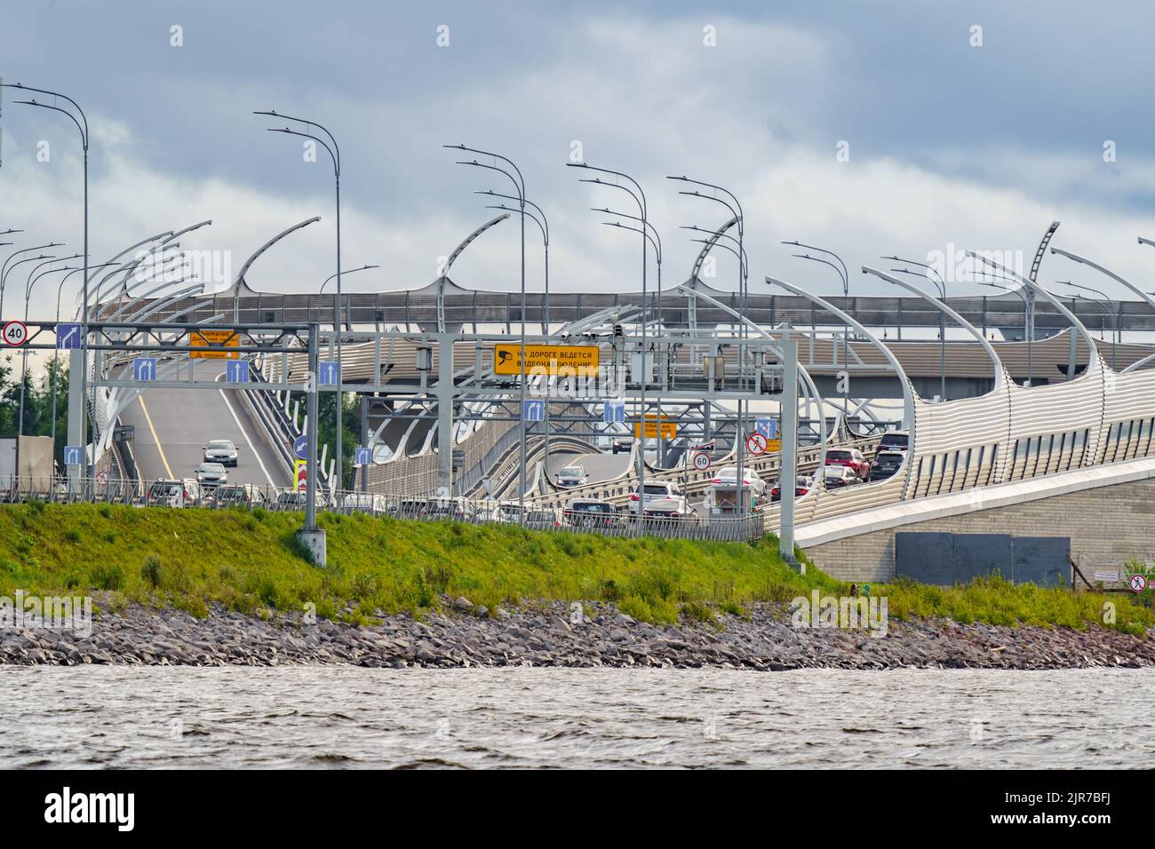 Russland, St. Petersburg, 29. Juli 2022: Ausfahrt von der Insel Vasiljewski auf die Schnellstraße, Straßenschilder über die Mautstraße, Autoverkehr an Stockfoto