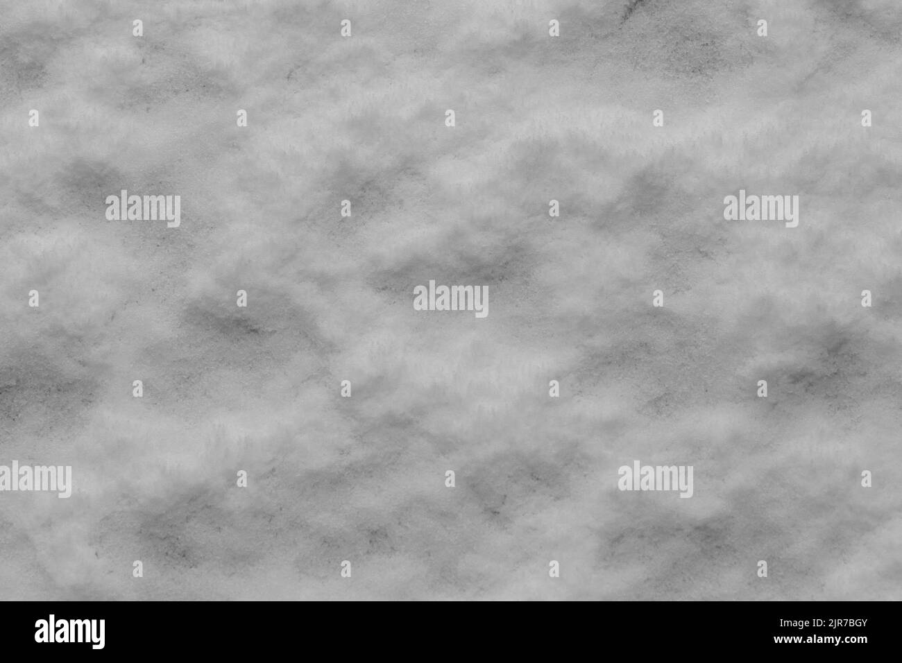 Schnee auf dem Boden ergibt ein flauschiges, strukturiertes Muster, das als Hintergrund verwendet werden kann. Stockfoto