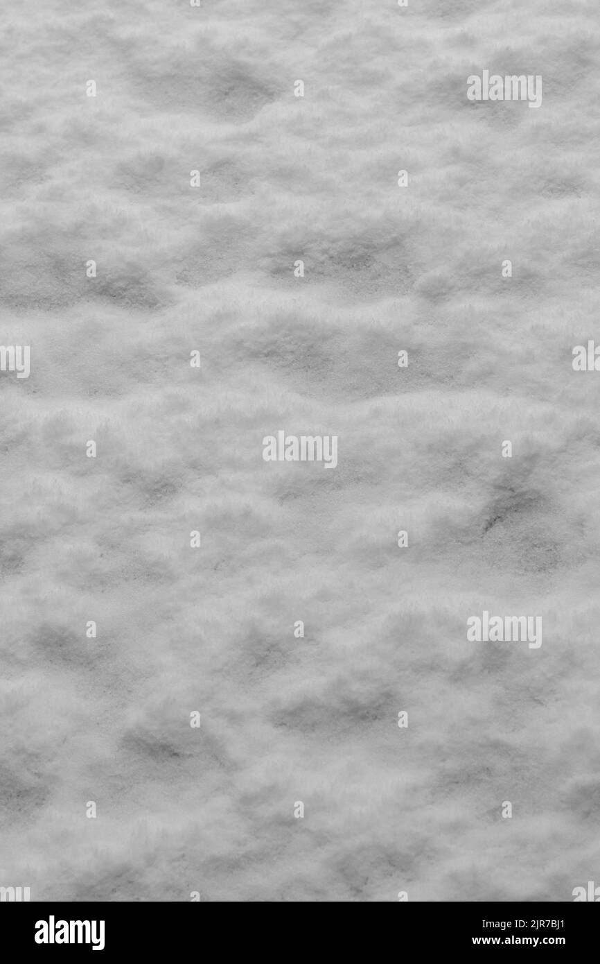 Schnee auf dem Boden ergibt ein flauschiges, strukturiertes Muster, das als Hintergrund verwendet werden kann. Stockfoto