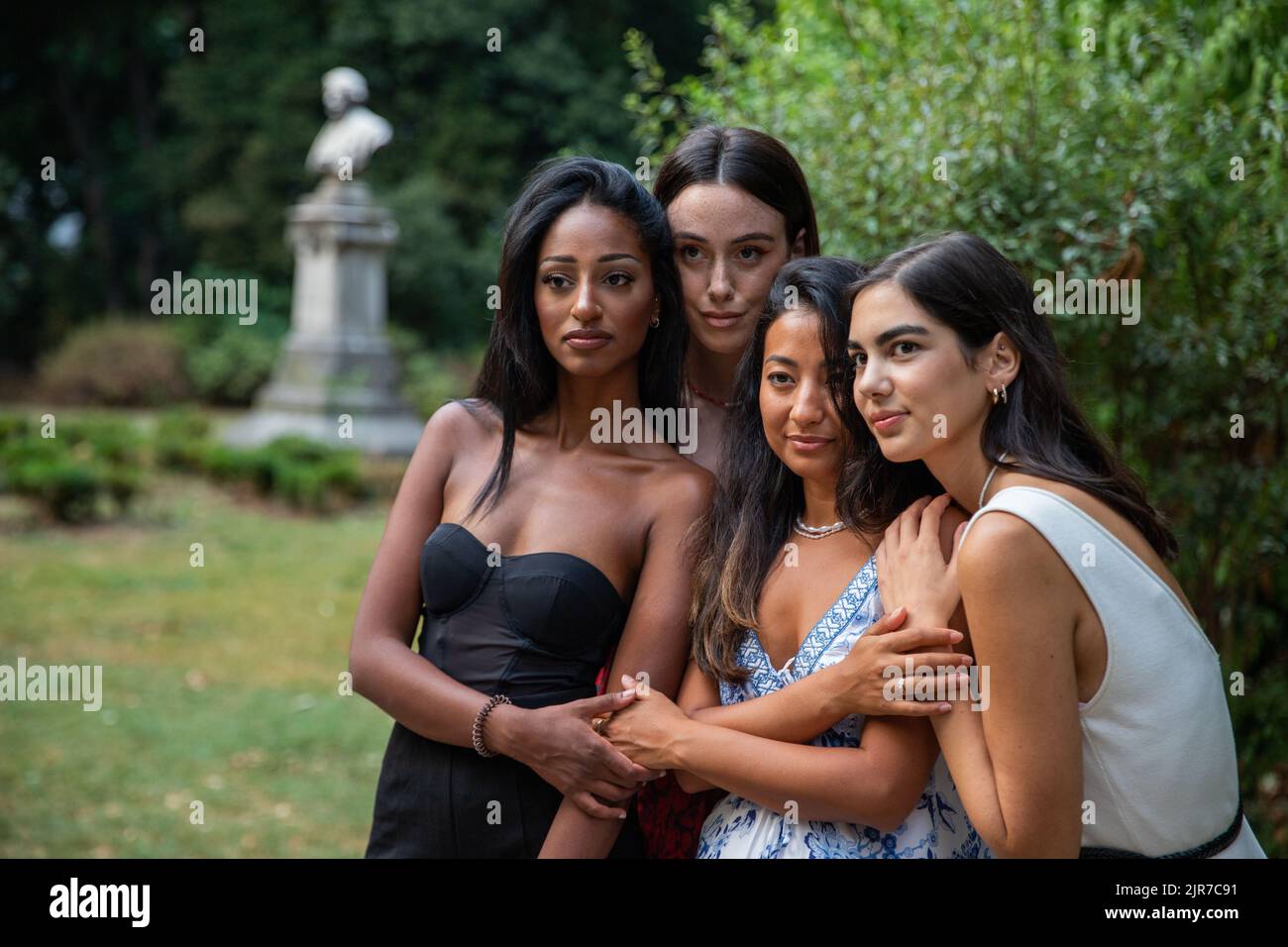 Vier Freundinnen verschiedener Ethnien treffen sich im Park, um Zeit zu verbringen. Konzept der Zweisamkeit Stockfoto