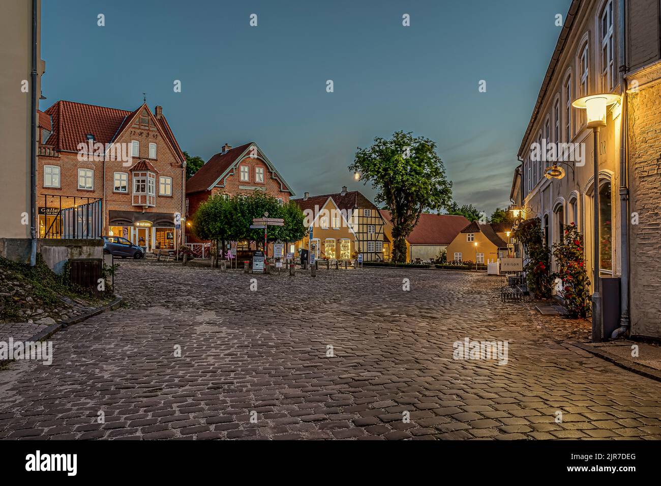 Der beleuchtete Platz in der kleinen dänischen Stadt Mariager während der blauen Stunde, Mariager, Dänemark, 5. August 2022 Stockfoto