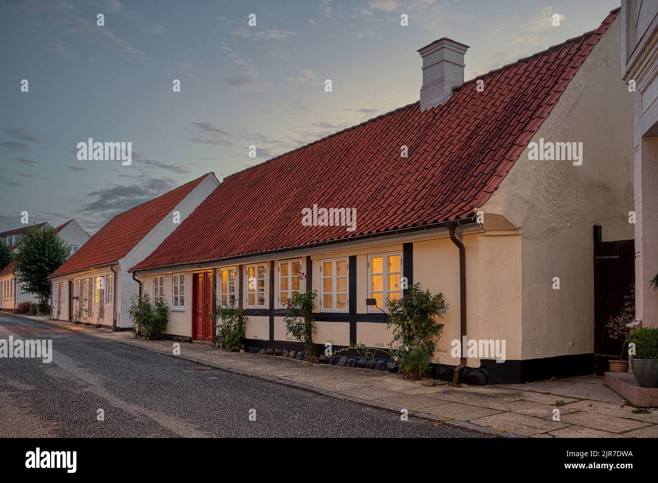 Lichter in den Fenstern eines alten Fachwerkhauses in der kleinen Stadt Mariager, Dänemark, 7. August 2022 Stockfoto