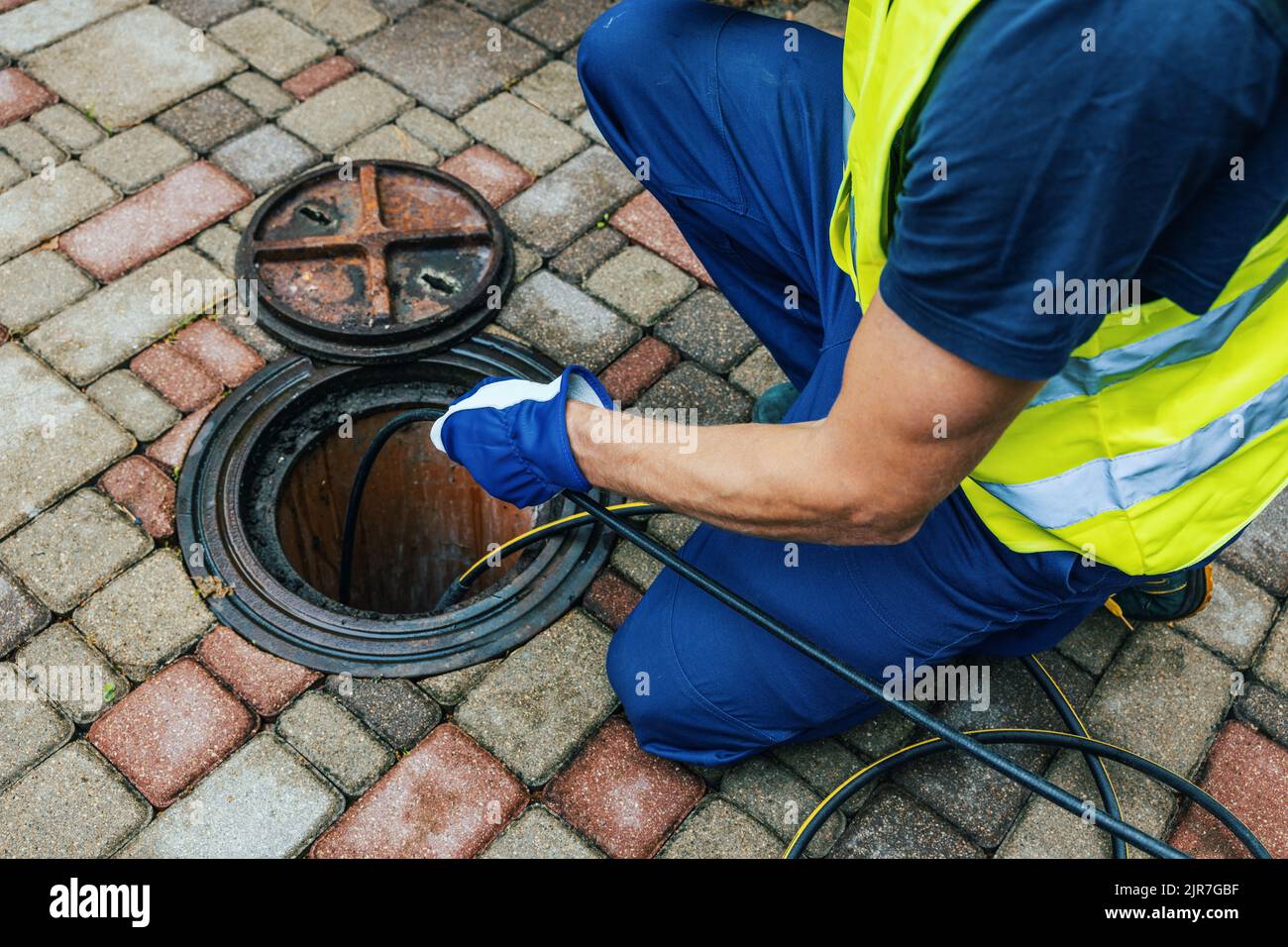 Servicemitarbeiter reinigen blockierte Kanalleitung mit Hydrojettierung Stockfoto