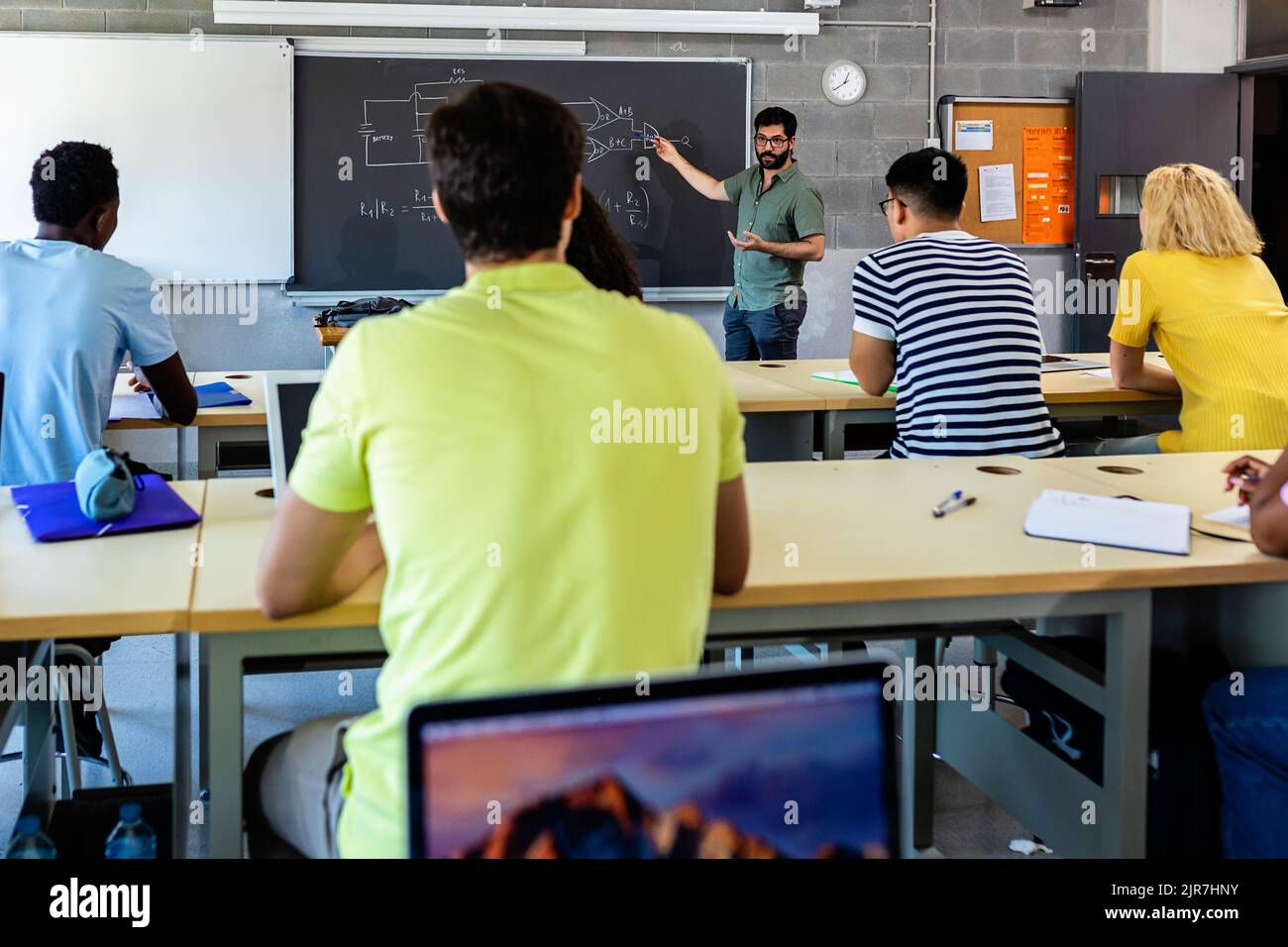Junger erwachsener männlicher Dozent, der während des Technologieunterrichts unterrichtet Stockfoto