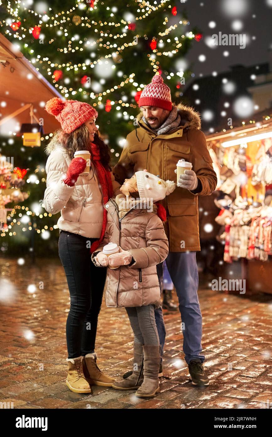 Familie mit Getränken zum Mitnehmen auf dem weihnachtsmarkt Stockfoto