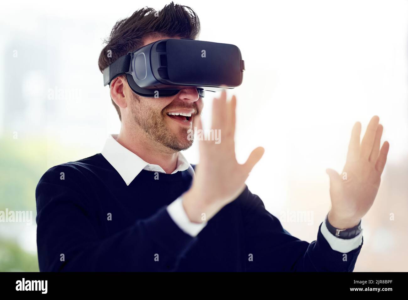 Neue Möglichkeiten sind immer in Reichweite. Ein Geschäftsmann, der ein VR-Headset im Büro trägt. Stockfoto