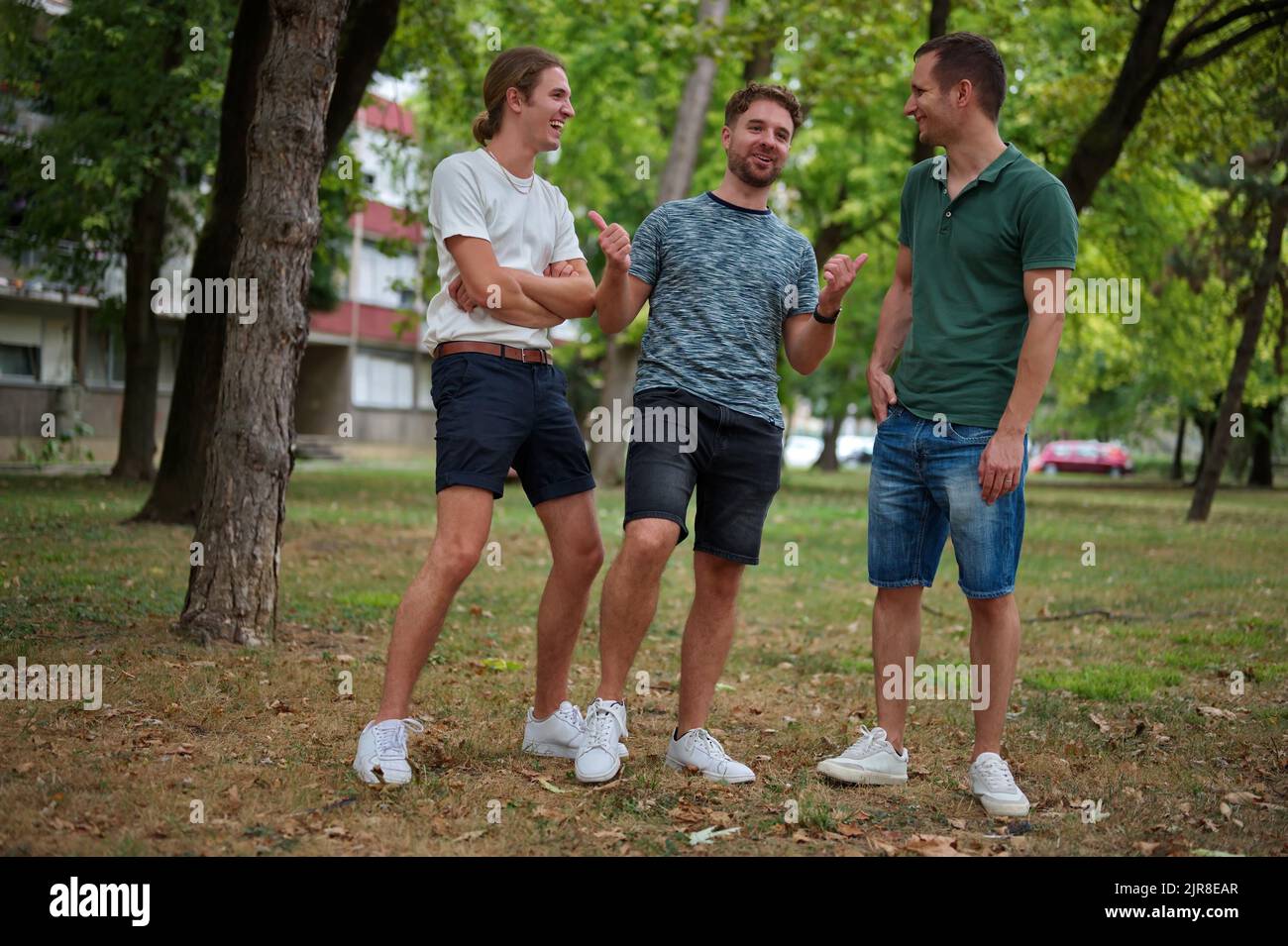 Drei hübsche junge Mann, der Spaß in einem Park hat Stockfoto