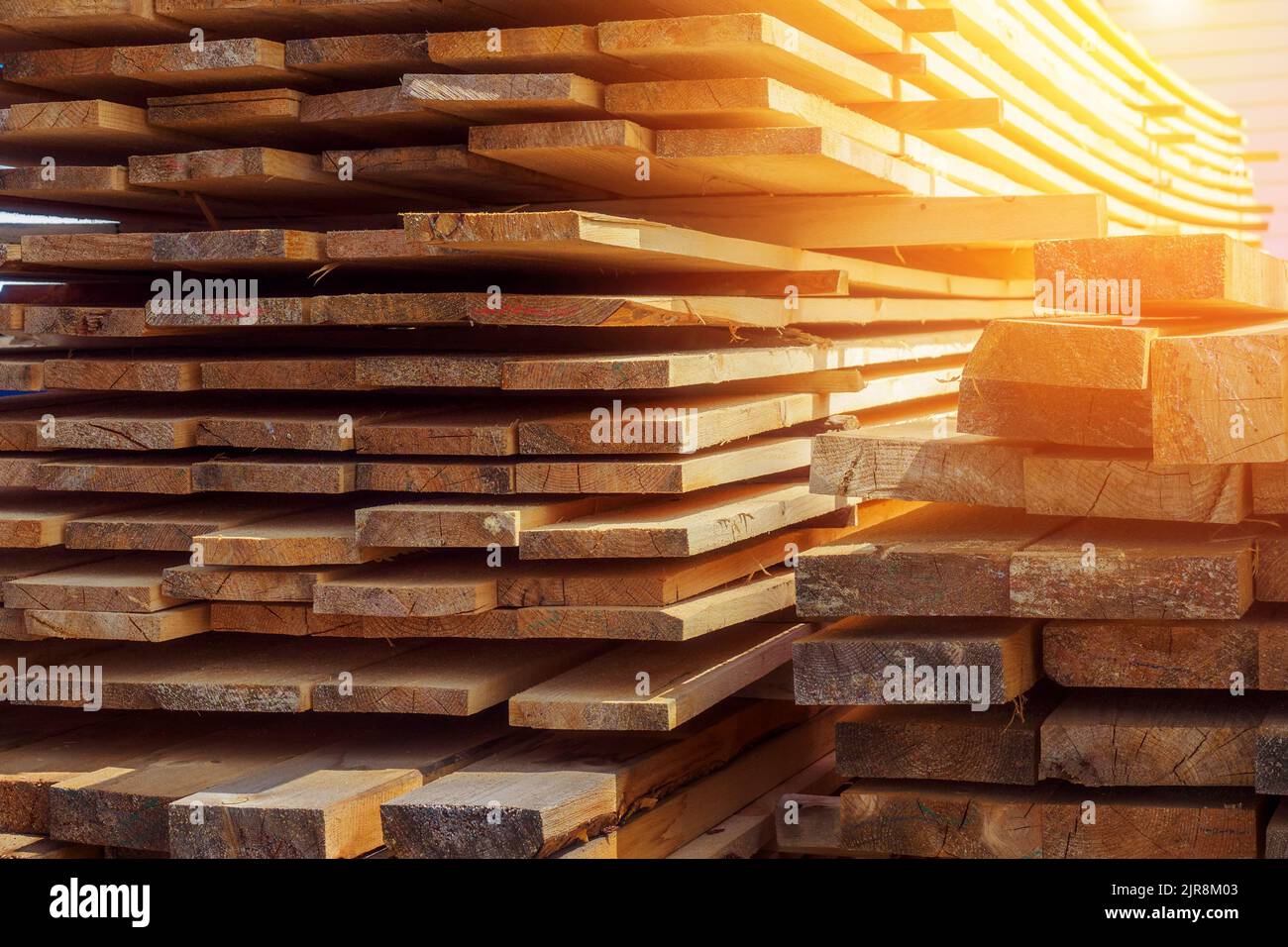 Holzbretter werden in einem Sägewerk oder einer Schreinerei gestapelt. Sägen Trocknen und Vermarktung von Holz. Industrieller Hintergrund Stockfoto