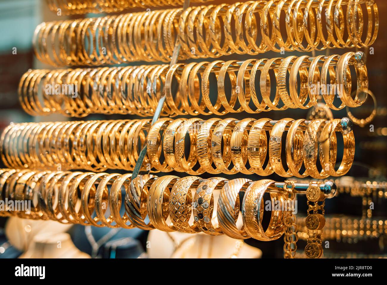 Ein Juweliergeschäft mit goldenem Schmuck, Armbändern und Accessoires. Das Konzept der Investitionen und Einsparungen mit Gold. Stockfoto