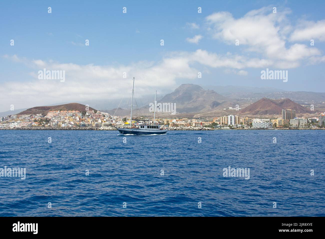 Küste mit Stadt, Schiff und Bergen von der Südküste der Kanarischen Insel Teneriffa, Los Cristianos, Spanien, Europa Stockfoto