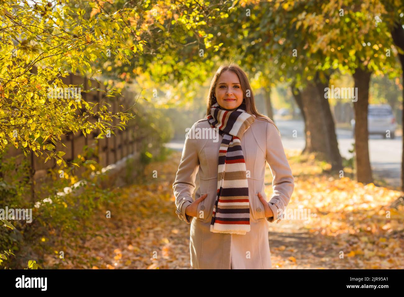 Glückliche Frau in warmen Kleidern im Park Stockfoto