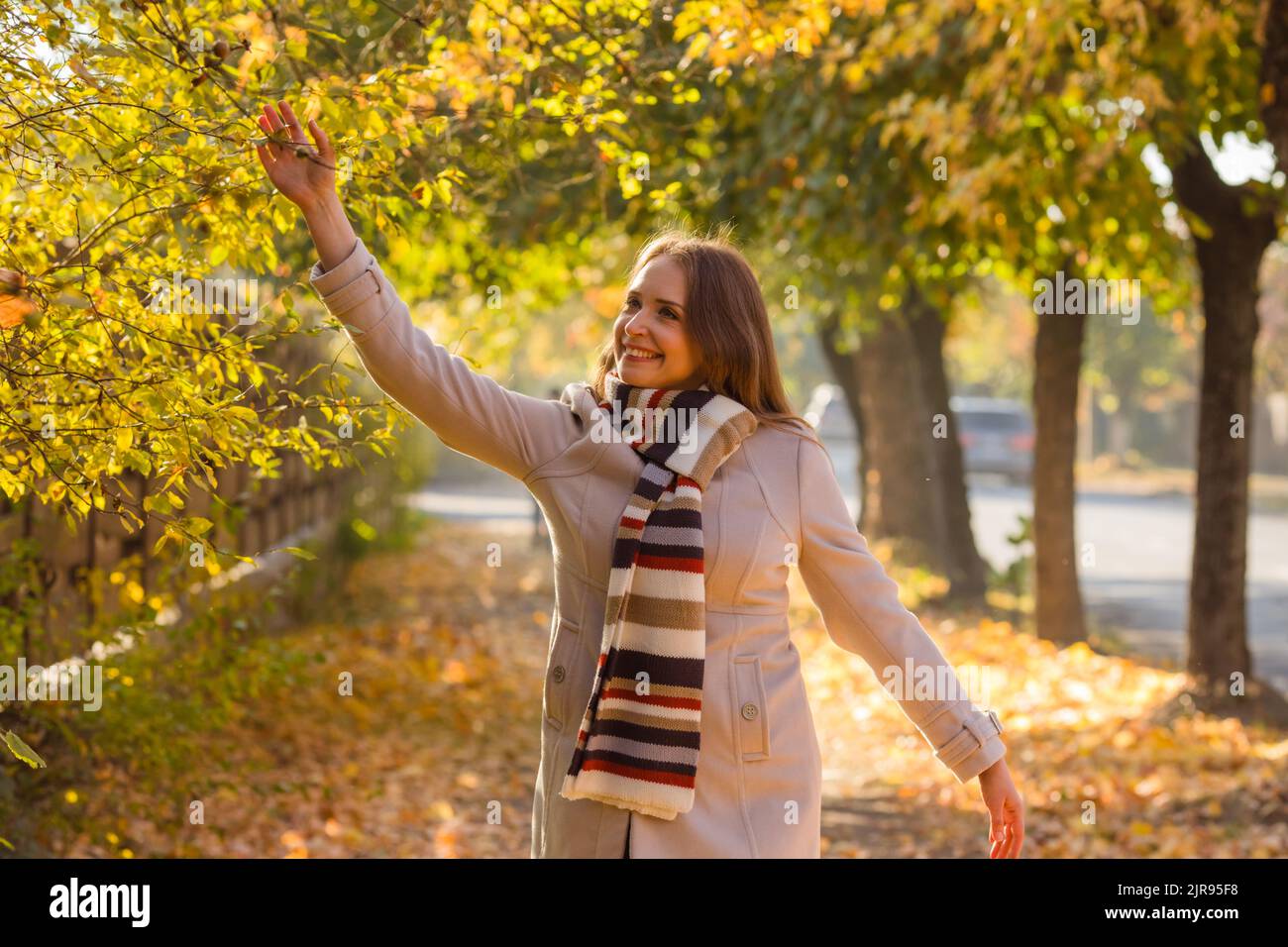 Glückliche Frau in warmen Kleidern im Park Stockfoto