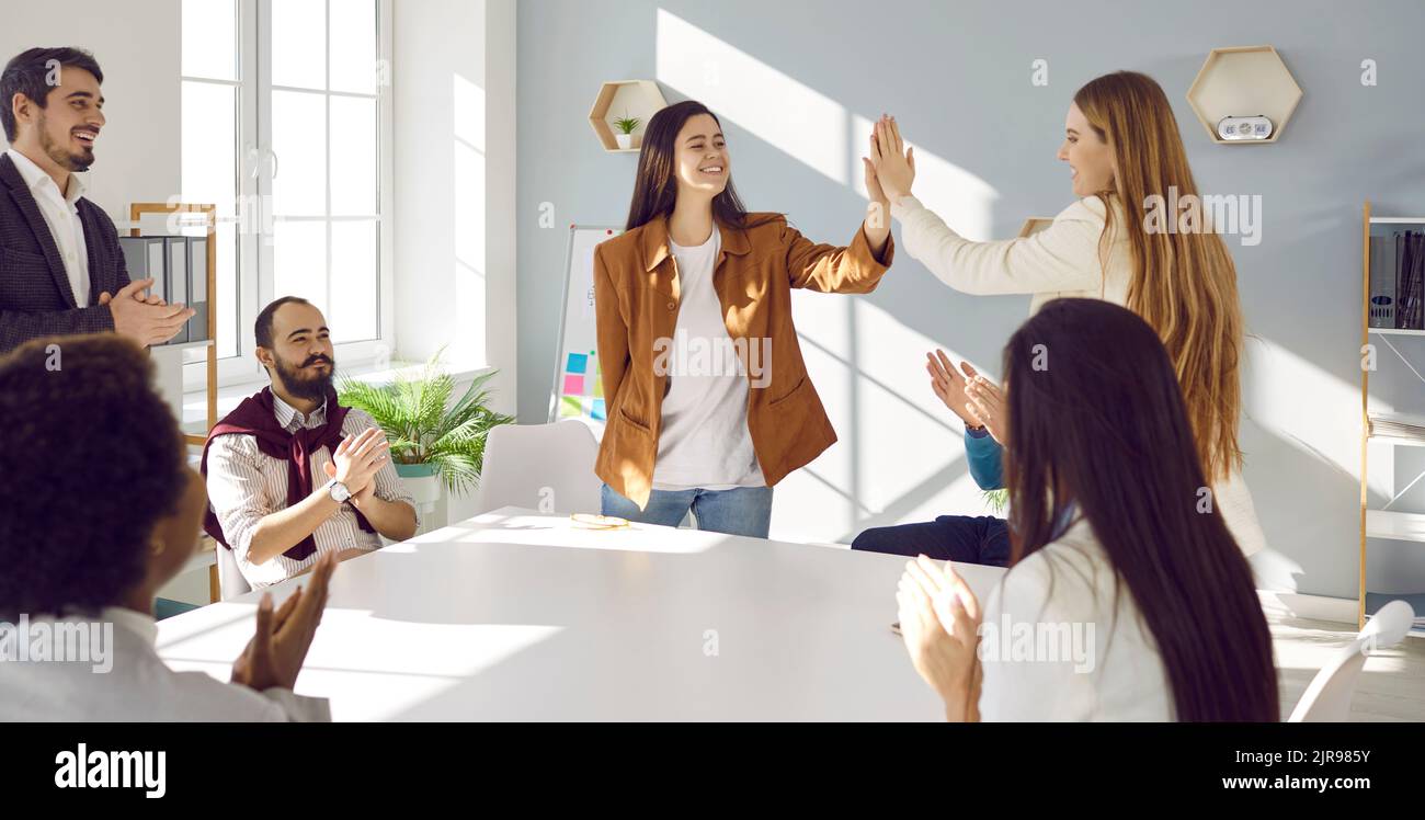Kollegen geben sich bei einem geschäftlichen Meeting, bei dem erfolgreiche Ergebnisse gefeiert werden, fünf Punkte. Stockfoto