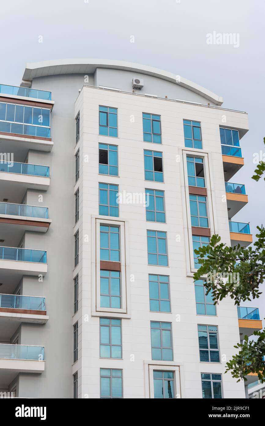 Modernes hohes Wohnapartmentgebäude mit französischen Fenstern. Vertikale Aufnahme. Stockfoto