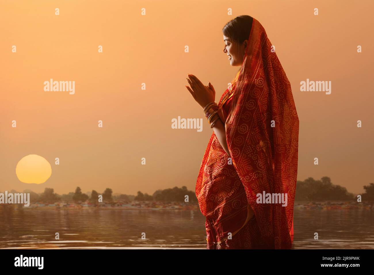 Frau aus Bihar bietet Gebete an die Sonne in den frühen Morgenstunden während Chhath Puja Festival Stockfoto