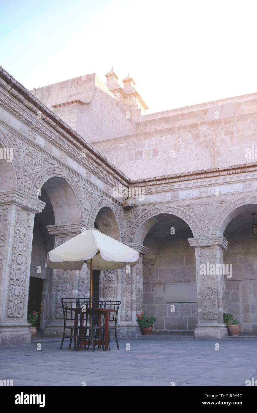 Café im Freien in der Kopfsteinpflasterstraße, malerische Straße mit traditionellen Häusern und Café-Tischen in der Stadt Arequipa in Peru. Stockfoto