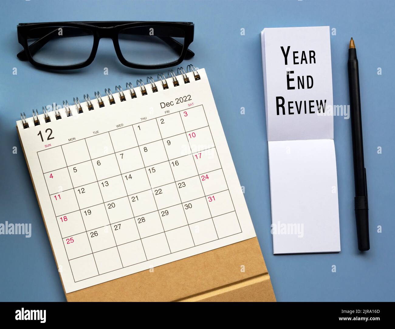 Tischkalender Dezember 2022 mit Text zum Year End Review auf Notizblock. Stockfoto