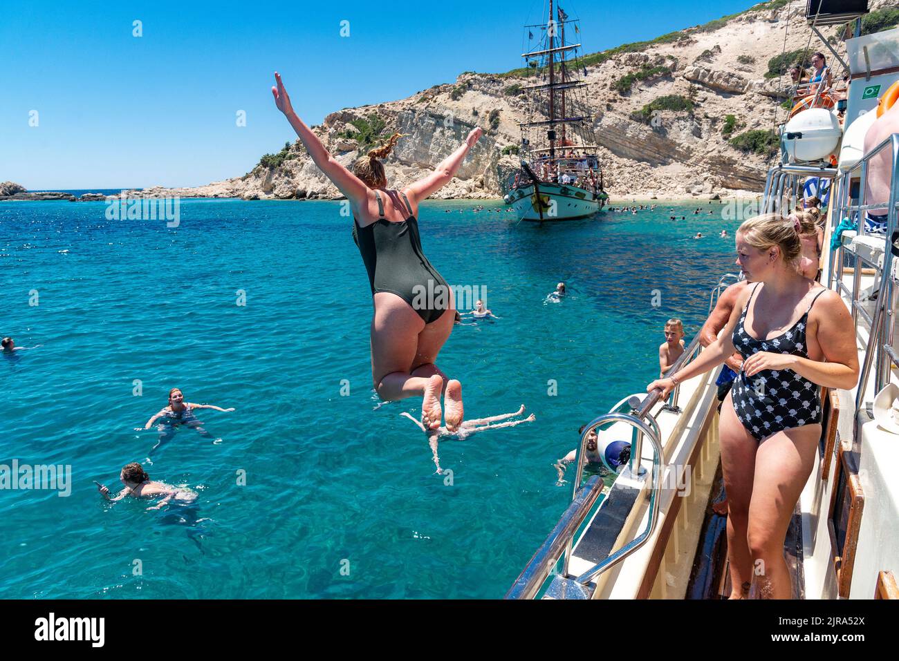 Springen und Schwimmen von einem Vergnügungsboot, Plati, Kreta, Griechenland. Stockfoto