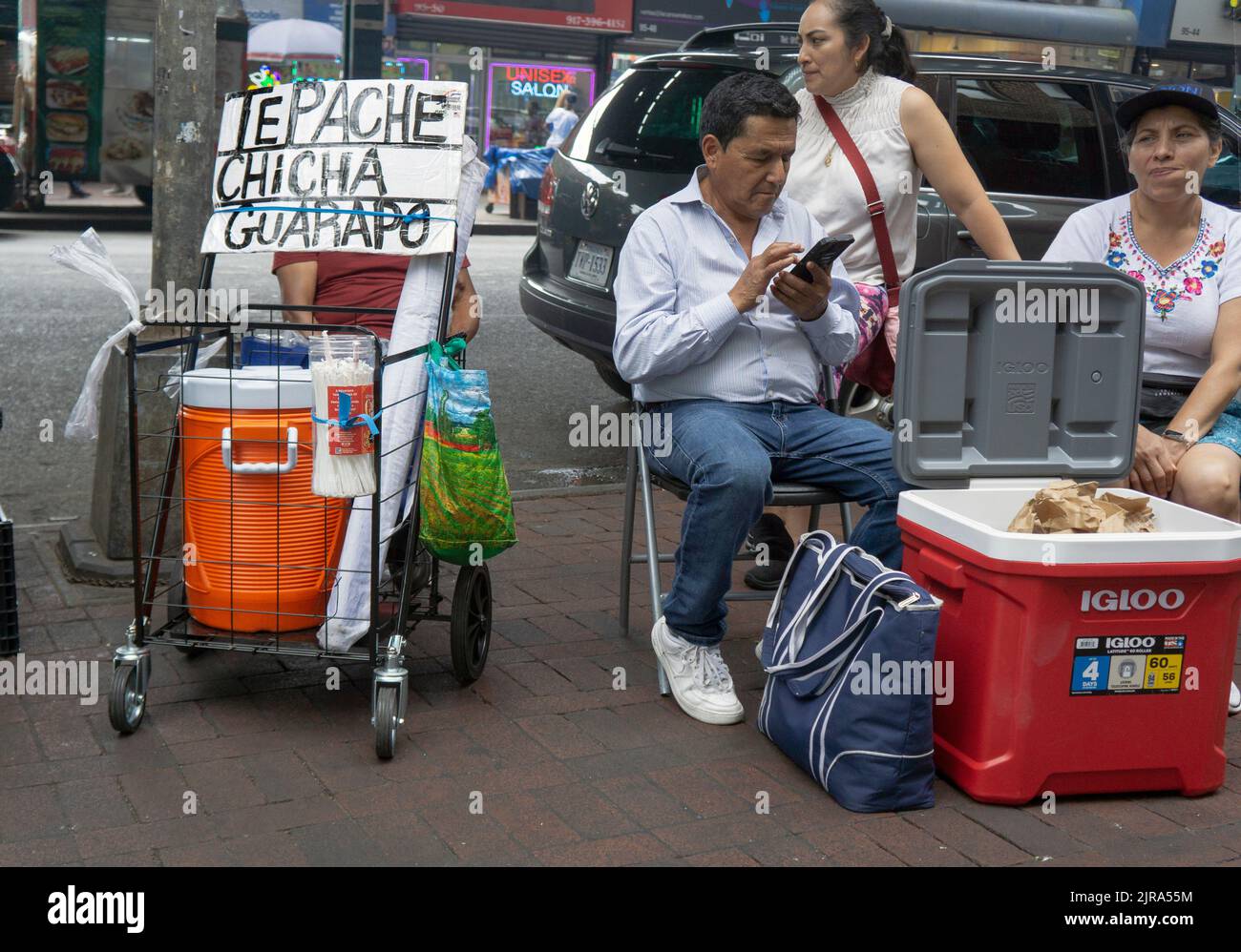 Eine Straßenszene auf der Roosevelt Ave. In Corona, einschließlich Verkauf eines kalten würzigen Getränks, Tepache Chicha Guarapo, wahrscheinlich Ananasgeschmack. In Queens, New York. Stockfoto