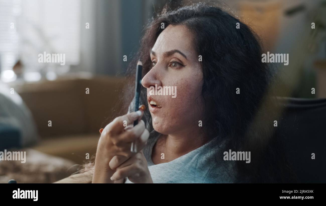 Schöne hübsche Frau mit einer Behinderung macht einen Abend Make-up mit Eyeliner in gemütlichen Hause am Tag Stockfoto