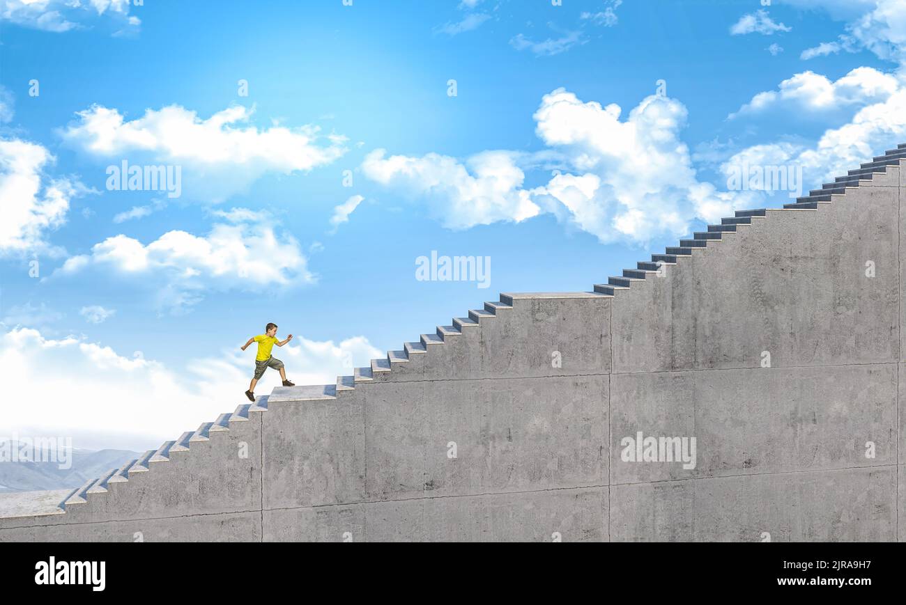 Das Kind rennt, um eine lange Betontreppe zu erklimmen Stockfoto