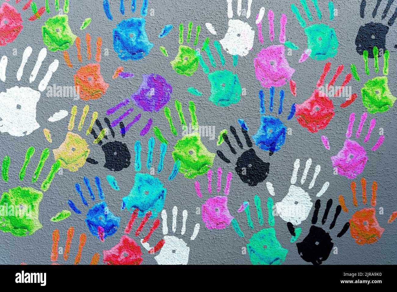 Farbige Handflächen an einer grauen Wand. Kinder-Handabdrücke Hintergrund. Charity, Joy, Party, Urlaubskonzept. Hochwertige Fotos Stockfoto