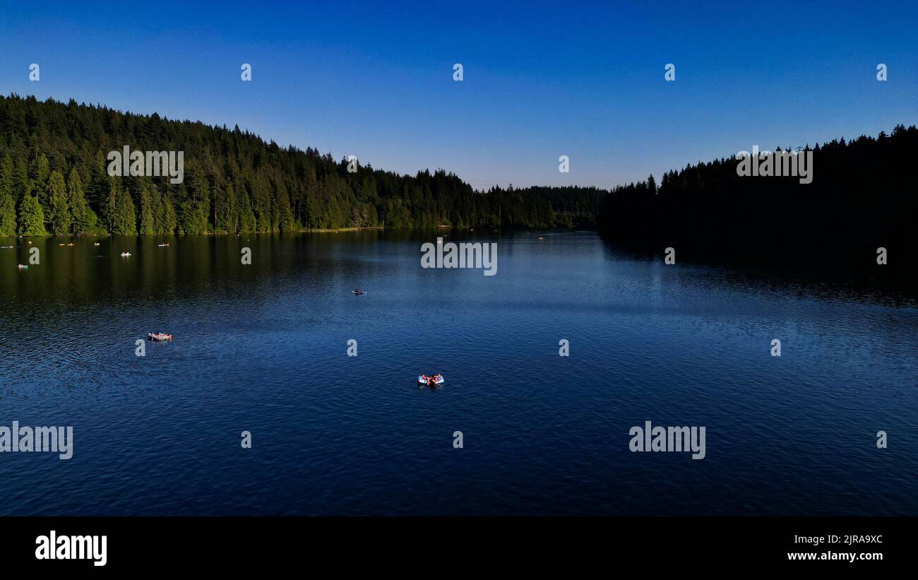 Eine wunderschöne Aussicht auf den Sasamat Lake, umgeben von dichten Bäumen in Port Moody, Kanada Stockfoto