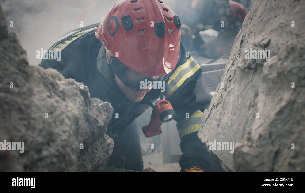 Verfolgung von Menschenschoß in Schutzuniform und Hardhat, der Mitarbeiter anruft und während der Rettungsmission nach dem Erdbeben mit Überlebenden unter Trümmern spricht Stockfoto