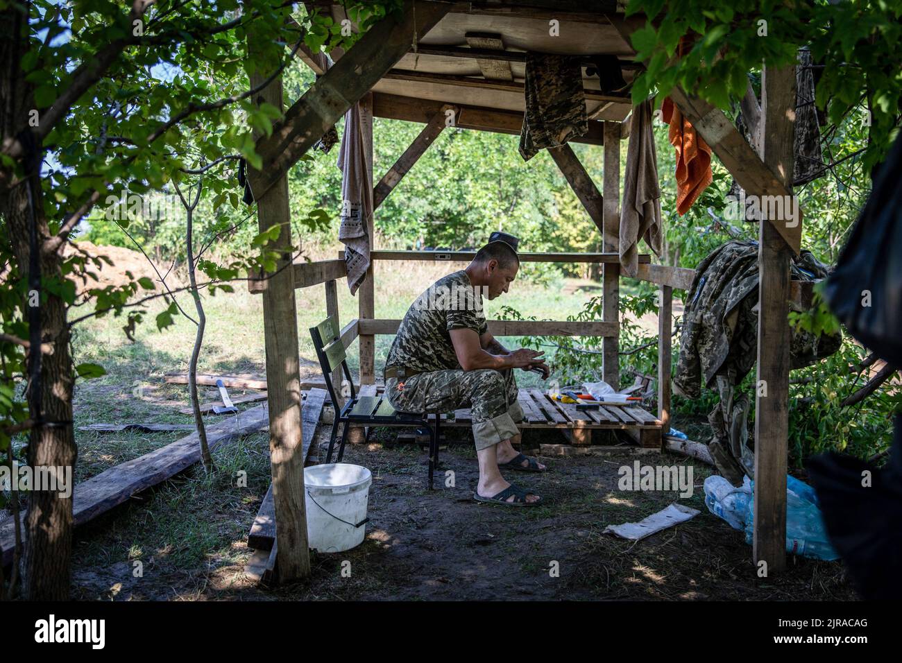 Ein ukrainischer Soldat wurde bei einer nicht offengelegten Verteidigungsposition im Gebiet Mykolaiv, Ukraine, mit seinem Telefon gesehen. Ukrainische Beamte haben die Befangenheit geltend gemacht, um ihr Territorium zurückzugewinnen, und eine Gegenoffensive im Süden, einschließlich des Gebiets Mykolaiv, durchgeführt, um die russischen Streitkräfte im Gebiet Cherson anzugreifen. Das Gebiet Mykolaiv, mit der strategischen Stadt Ukraine auf der Südseite mit Zugang zum Schwarzen Meer und ist eines der wichtigsten Schiffbauzentren, hatte früher 476.101 Einwohner (2021 Einwohner), wurde aber nach der umfassenden Invasion von Russ schwer belagert und bombardiert Stockfoto