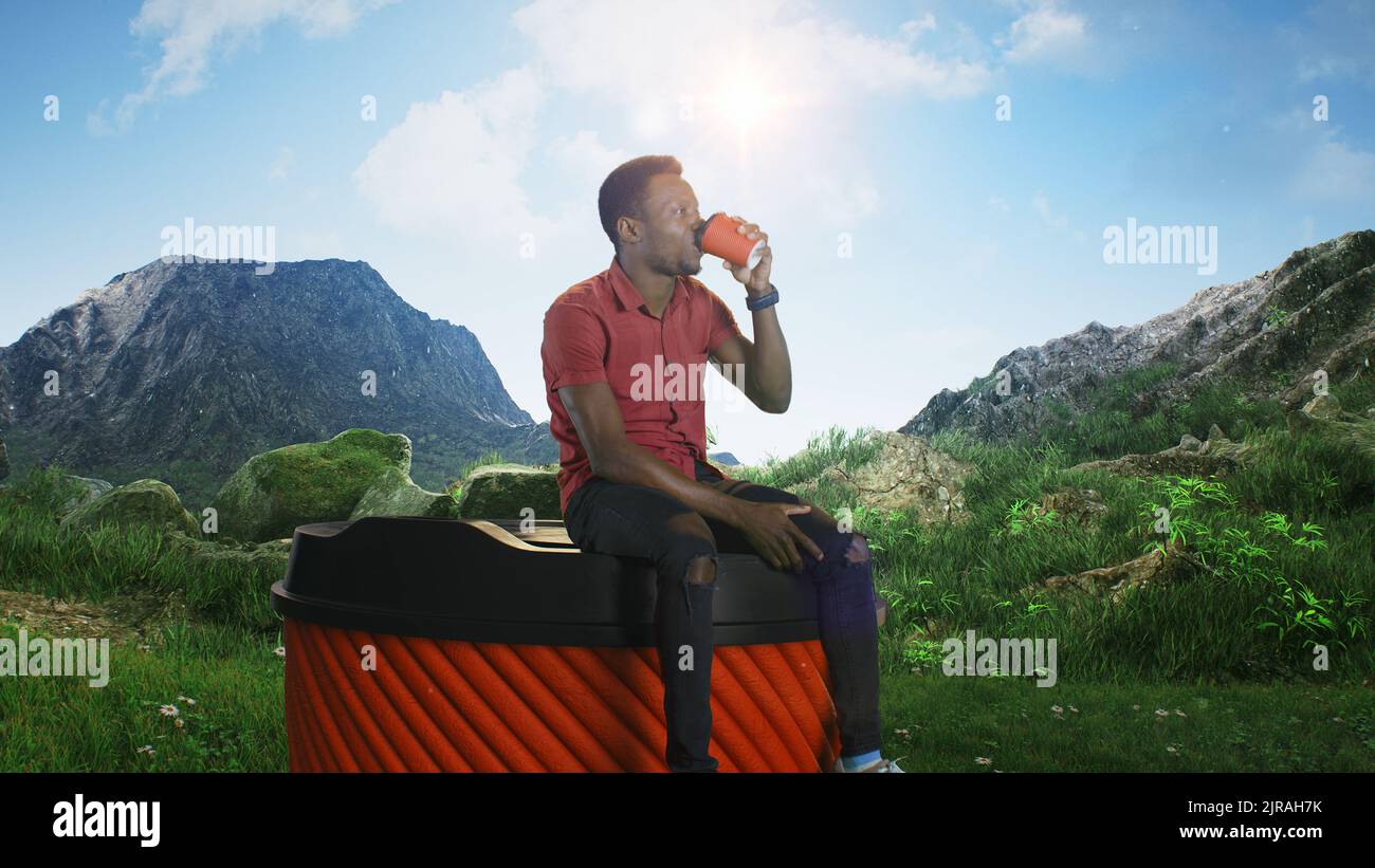Afroamerikanischer Mann in legerer Kleidung, der auf einer großen Tasse zum Mitnehmen sitzt und am sonnigen Morgen in den Bergen frischen Kaffee genießt Stockfoto