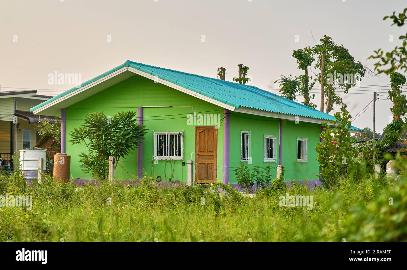Ein kleines einfaches Haus in einer grünen Landschaft. Stockfoto