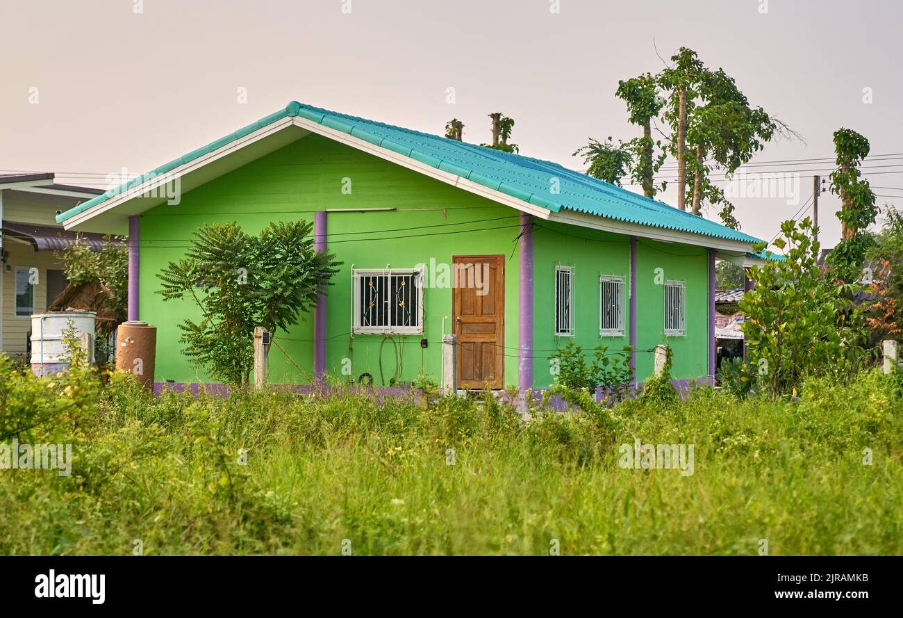 Ein kleines einfaches Haus in einer grünen Landschaft. Stockfoto