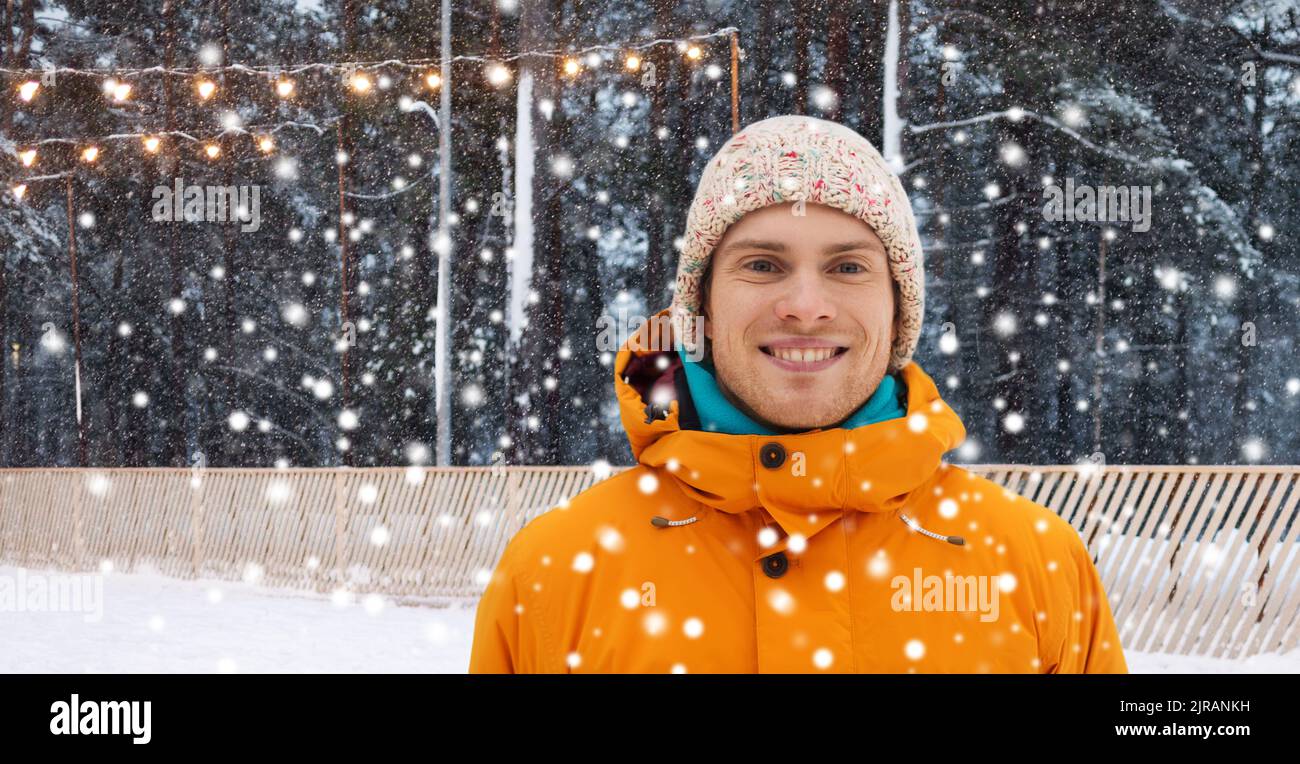 Glücklicher junger Mann auf der Eislaufbahn im Winter Stockfoto