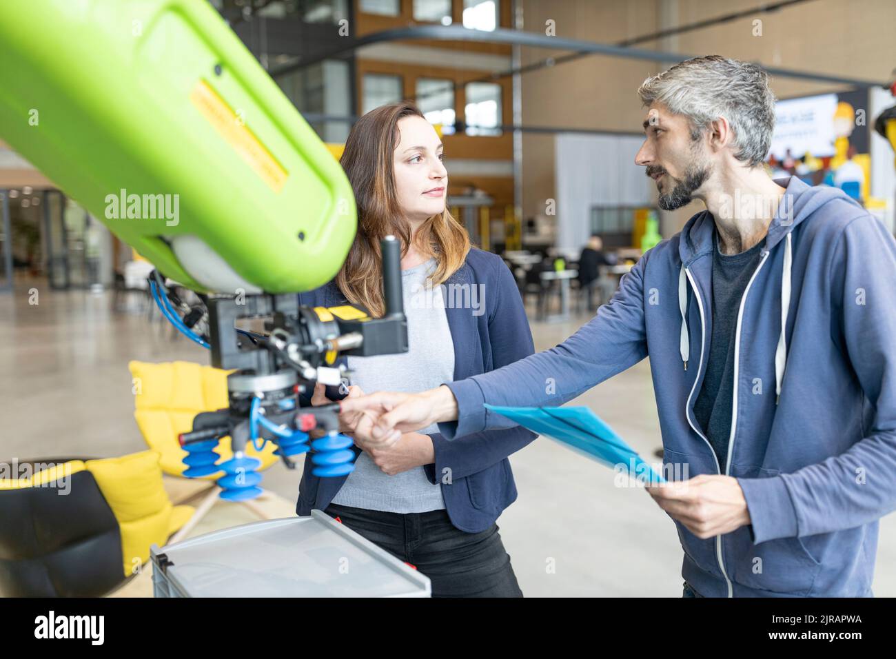 Techniker diskutieren technische Lösungen für Industrieroboter Stockfoto