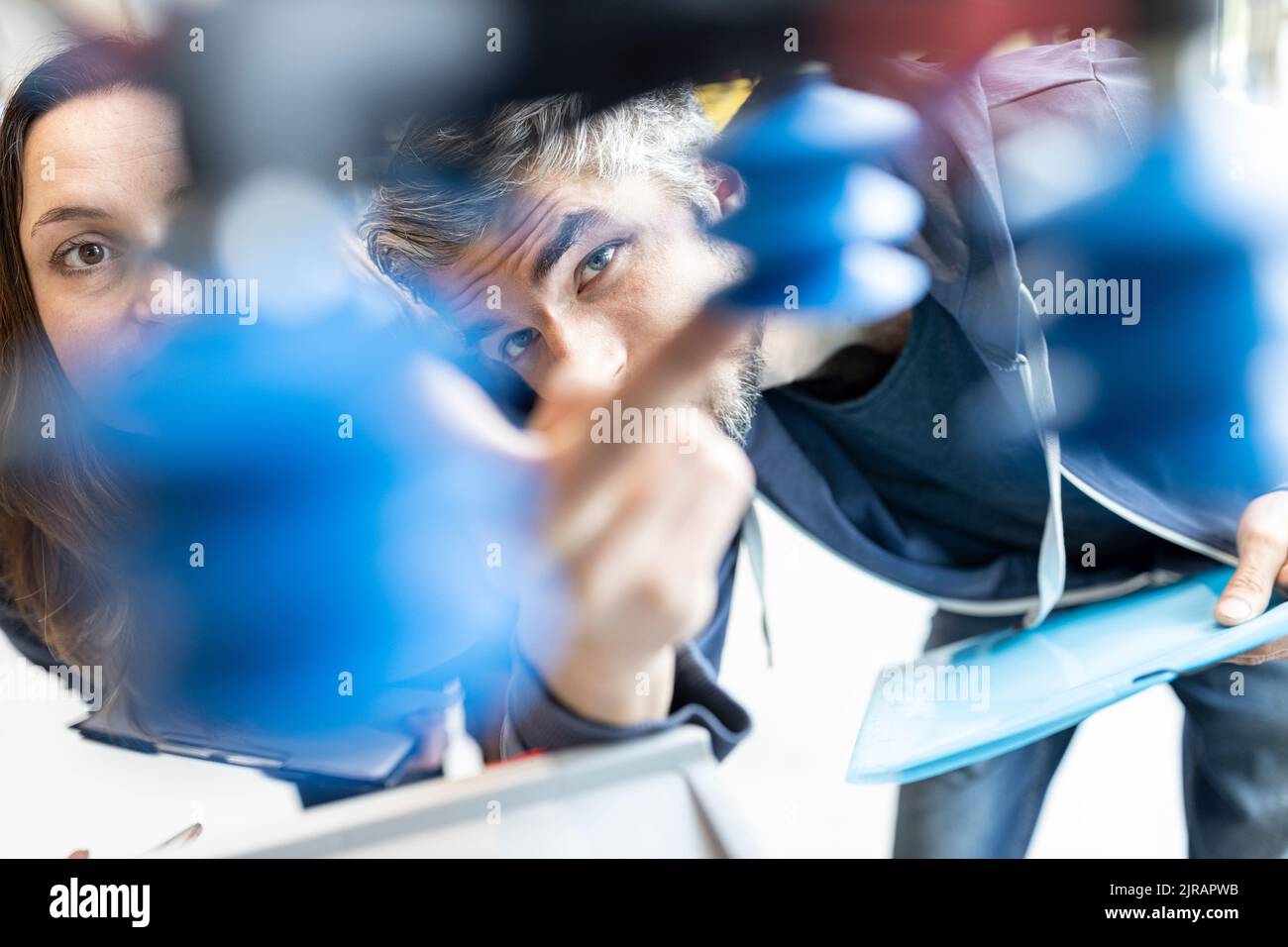 Techniker diskutieren technische Lösungen für Industrieroboter Stockfoto