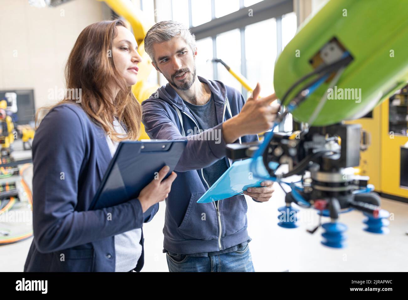 Techniker diskutieren technische Lösungen für Industrieroboter Stockfoto