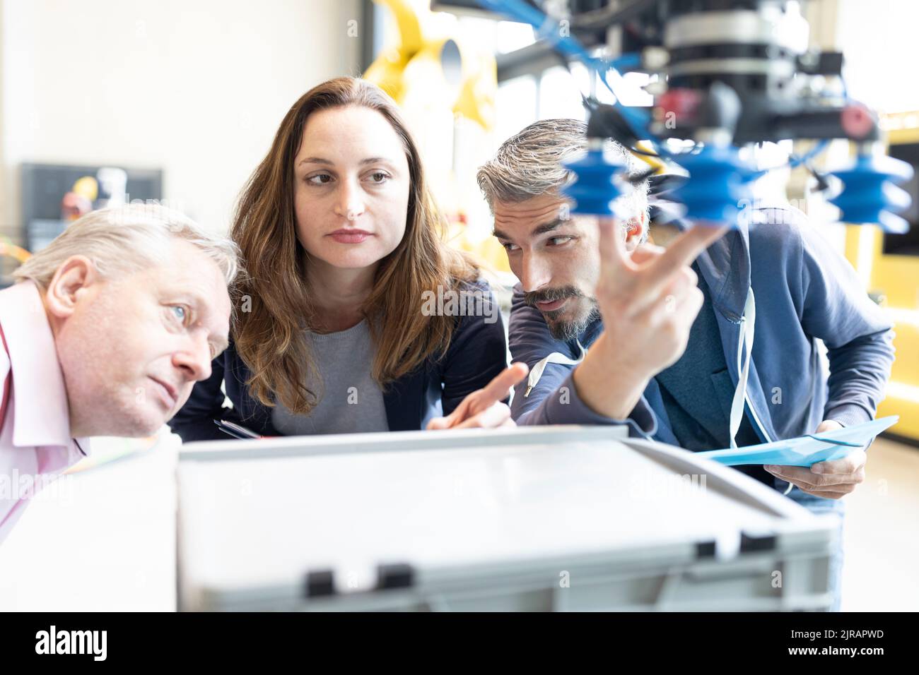 Techniker zeigen einem leitenden Kollegen einen neuen Industrieroboter Stockfoto