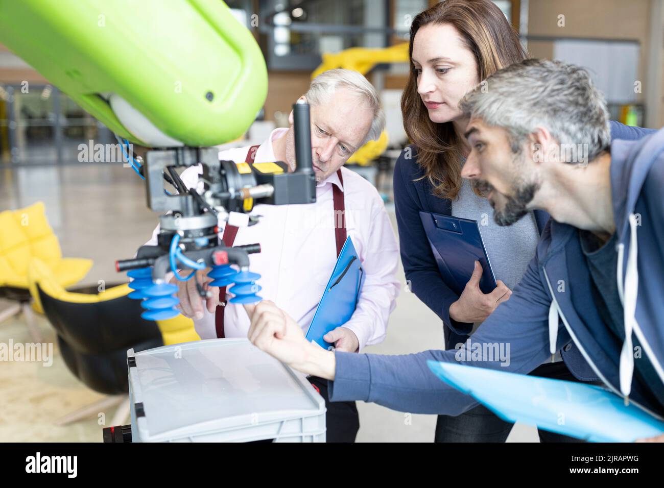 Techniker zeigen einem leitenden Kollegen einen neuen Industrieroboter Stockfoto