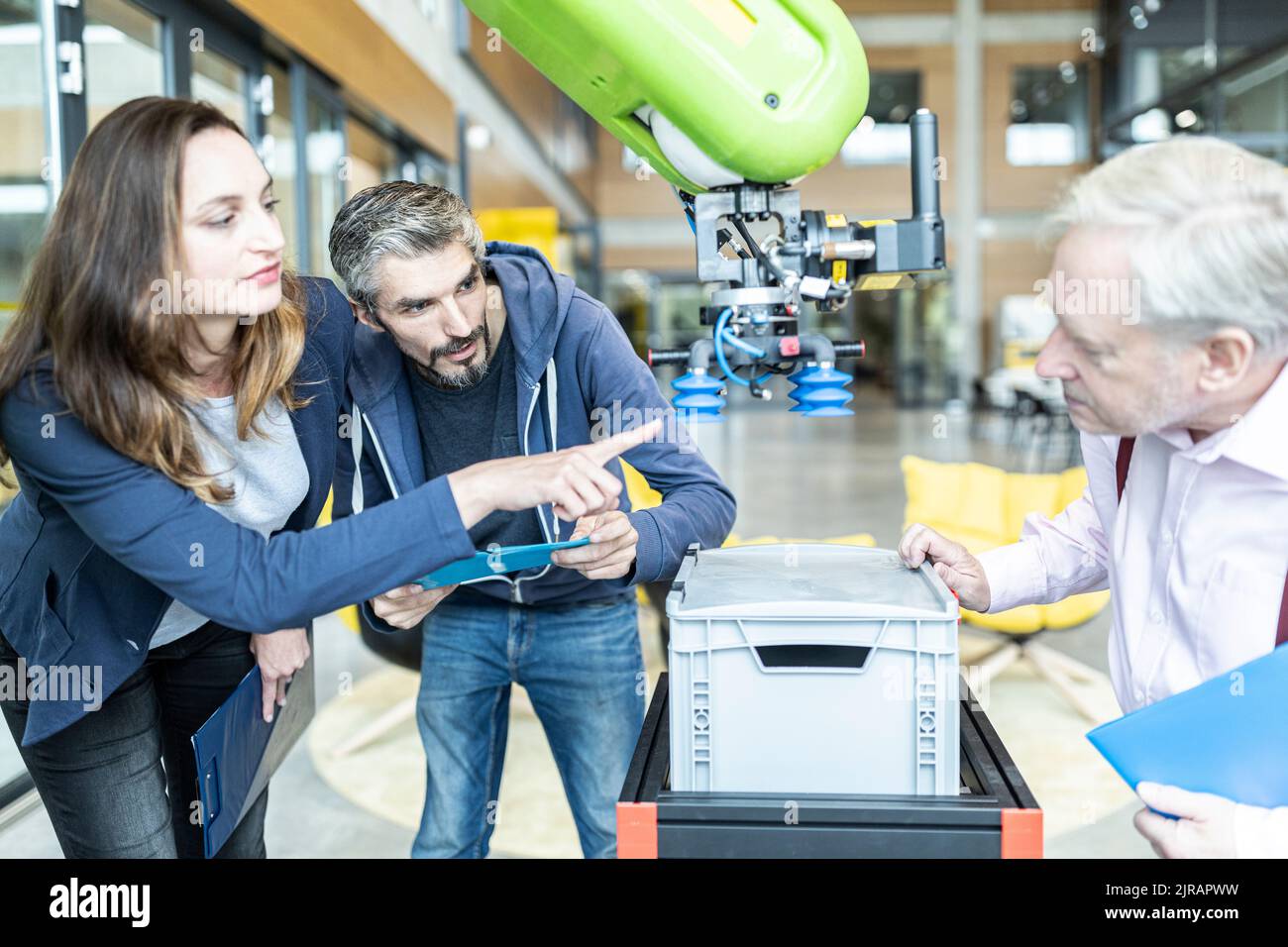 Techniker zeigen einem leitenden Kollegen einen neuen Industrieroboter Stockfoto